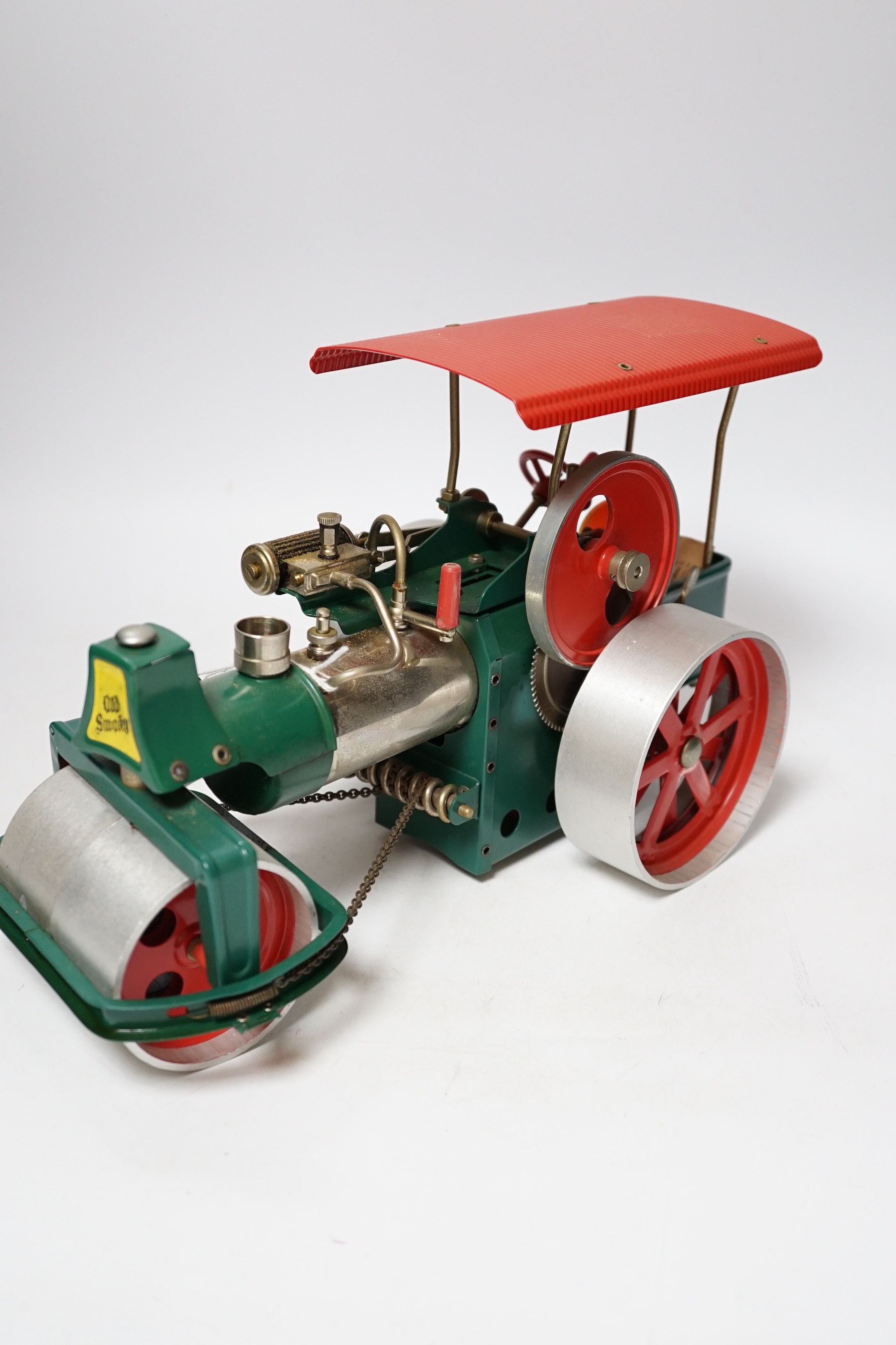 A Wilesco live steam tinplate and aluminium model Road Roller, missing its chimney